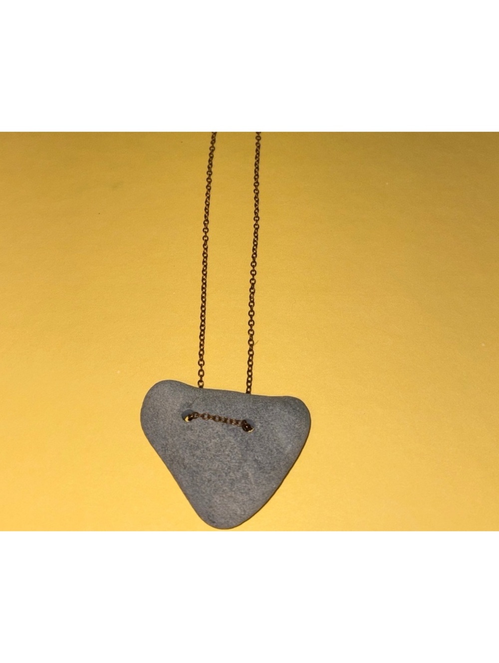 handmade necklace with a gray beach stone pendant threaded on a chain